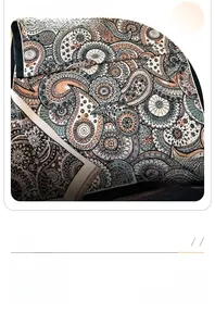 Close-up of bohemian Paisley pattern scarf with decorative fringe in peach and navy blue