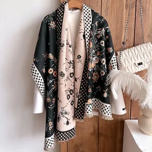 Detail of vintage floral pattern scarf with handmade fringe on a wooden hanger