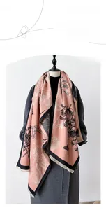Detail of pashmina scarf with pink and grey floral patterns and delicate tassels