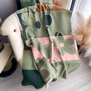 Detailansicht eines dicken Winterschals mit Blumenmuster und feiner Randnaht
