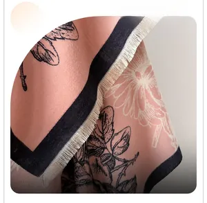 Close-up of pink floral scarf with soft brushed cashmere feel and cream fringe detail