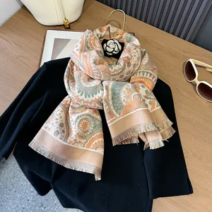 Detail view of ethnic paisley shawl with orange and teal prints and fringe trim