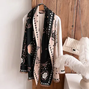 Detail view of the vintage camellia knit pattern and soft fringe on the thick winter scarf