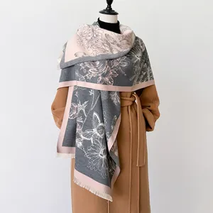 Detail of cashmere-like scarf showing hand-drawn rose motifs and tassels on a mannequin