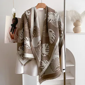 Détail d'un châle pashmina à motif de feuilles avec franges et texture douce