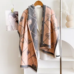 Sciarpa tipo cashmere rosa e grigia con cuori e nappe su giacca bianca elegante