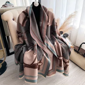 Detail showing jacquard horse pattern and fringe edges on a thick nude pink winter shawl