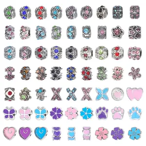 Gros plan de 63 perles style Pandora avec strass roses et détails en émail coloré