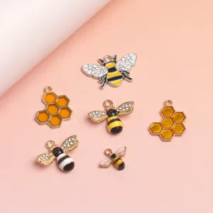 Detail van bij- en honingraatbedeltjes met emaille coating en kleine kristallen