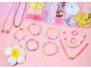 Détail d'un kit de perles colorées DIY avec boîte, outils et modèles de bracelets finis