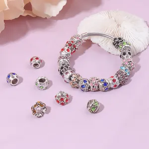 Bracelet DIY avec perles de cristal colorées et maille argentée sur fond lavande doux