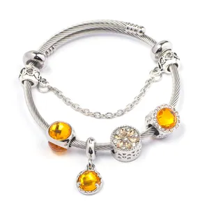 Dettaglio di un bracciale in argento con pietre preziose arancioni e ciondoli a cuore