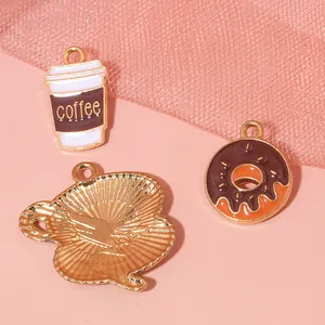 Detailed view of DIY coffee cup and donut alloy charms with golden enamel finish