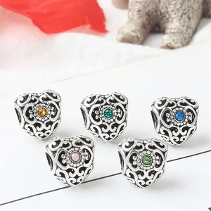 Macro detail of heart-shaped alloy charms with colorful rhinestones and retro patterns