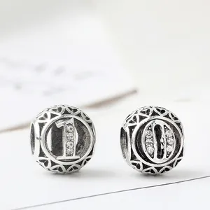 Charm d'argento con numeri 0 e 1, strass trasparenti e cuori traforati laterali