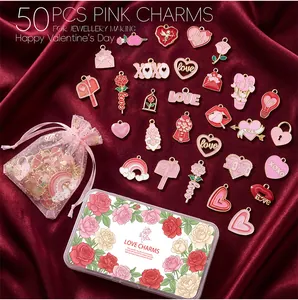Vue à plat de 50 breloques en émail rouge en forme de cœur et de rose avec coffret
