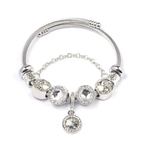 Silver stainless steel cable bracelet with crystal beads and heart pendant on white background