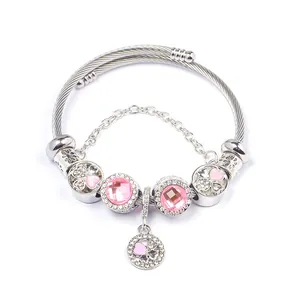 Detail of beaded steel cable bracelet with pink crystals and heart charms