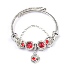 Detail of clover and heart charms on double-strand stainless steel beaded bracelet