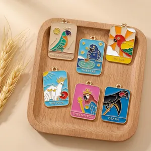 Detail of tarot parrot enamel pendants with gold finish rings in a wooden tray