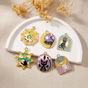 Detail of tarot animal enamel charms including cats and sun patterns on white tray