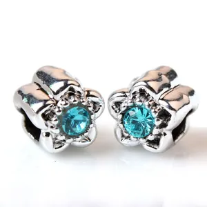 Boucles d'oreilles fleur en argent avec cristal bleu océan sur fond blanc pur