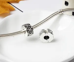 Detailed close-up of antique silver geometric alloy spacer beads on a snake chain