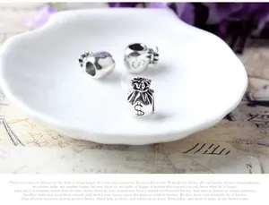 Pendentifs porte-monnaie en argent avec signe dollar dans une coupelle blanche