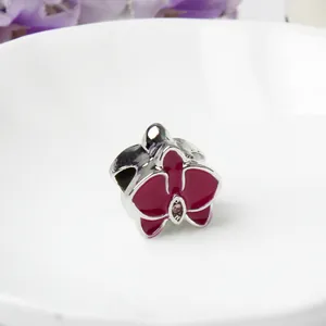Detalle de una cuenta de flor en esmalte rosa con circonita central para pulseras de bricolaje