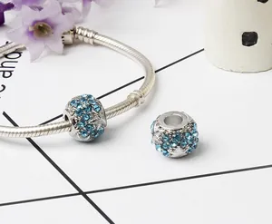 Close-up of a silver snake chain bracelet featuring two sparkling blue rhinestone charms