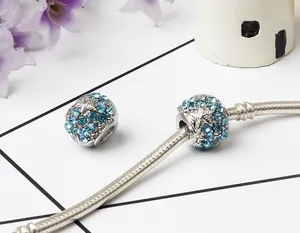Close-up of blue starfish rhinestone beads on a silver charm bracelet with marine decor