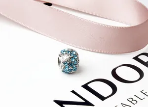 Macro detail of silver alloy bead with light blue rhinestones for DIY bracelets