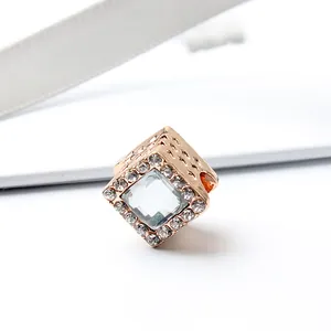 Macro-opname van roségouden vierkante kraal met sprankelende strass steentjes
