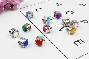 Vista macro de cuentas de plata con piedras de colores y diseño de corazones