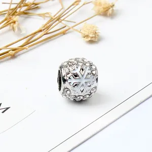 Makroaufnahme von versilbertem Schneeflocken-Charm mit Strasssteinen für DIY-Armbänder