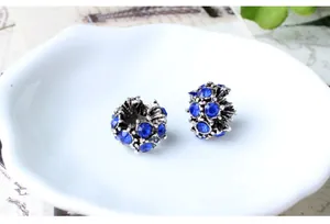 Vue macro de perles fleurs en cristal bleu sur plateau céramique et carte vintage