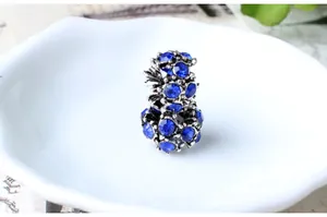 Détail macro d'une breloque fleur en strass bleu avec finition argent antique