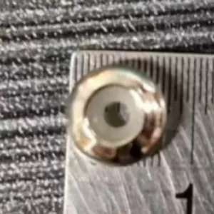 Perle d'espacement O-ring en métal argenté sur règle montrant la taille 8-10 mm