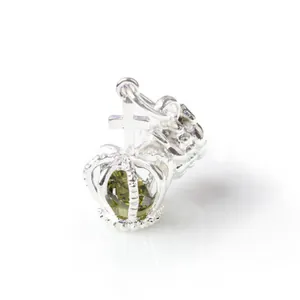 Primer plano detallado de un colgante de corona de plata con piedra de cristal verde para joyas