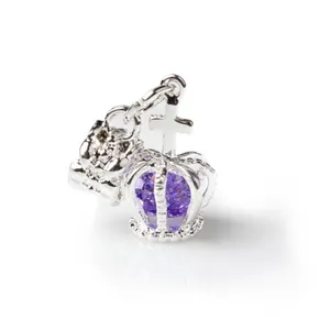 Vista macro de colgante corona de plata con cristal púrpura y dije de oso para joyería