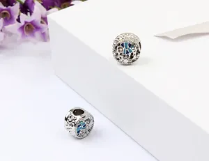 Gros plan de perles rondes en forme de coquillage bleu océan aux détails ajourés.