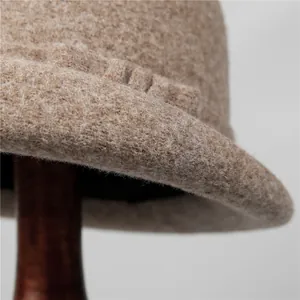 Detailed close-up of premium wool felt material and rolled edge on the tan cloche hat