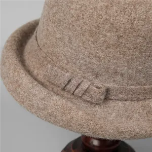 Detailed close-up of wool felt trilby hat with decorative band on a wooden stand