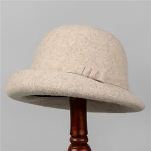 Elegant beige wool cloche hat with ribbon bow detail on a wooden display stand