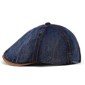 Vintage denim newsboy cap in dark blue with brown leather brim and contrast stitching