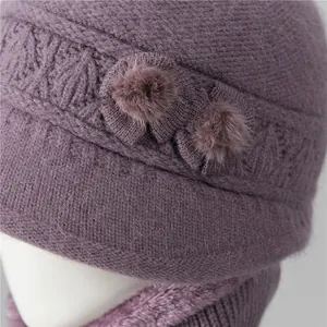 Detalle de gorro de invierno de punto morado con lazo decorativo y pompones suaves