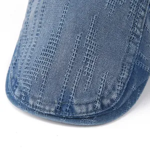 Macro detail of washed blue denim brim with decorative vertical stitching and twill texture