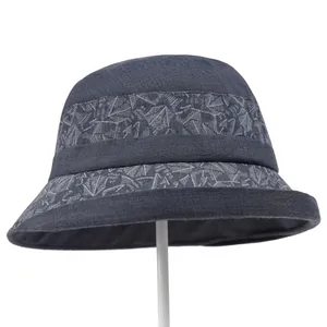 Detail of grey sun hat for elderly women showing leaf pattern and textured cotton fabric
