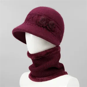 Detalle de conjunto de gorro y bufanda de punto rojo vino con elegante adorno floral