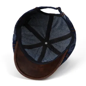 Vintage denim newsboy cap with brown leather brim shown from an internal view
